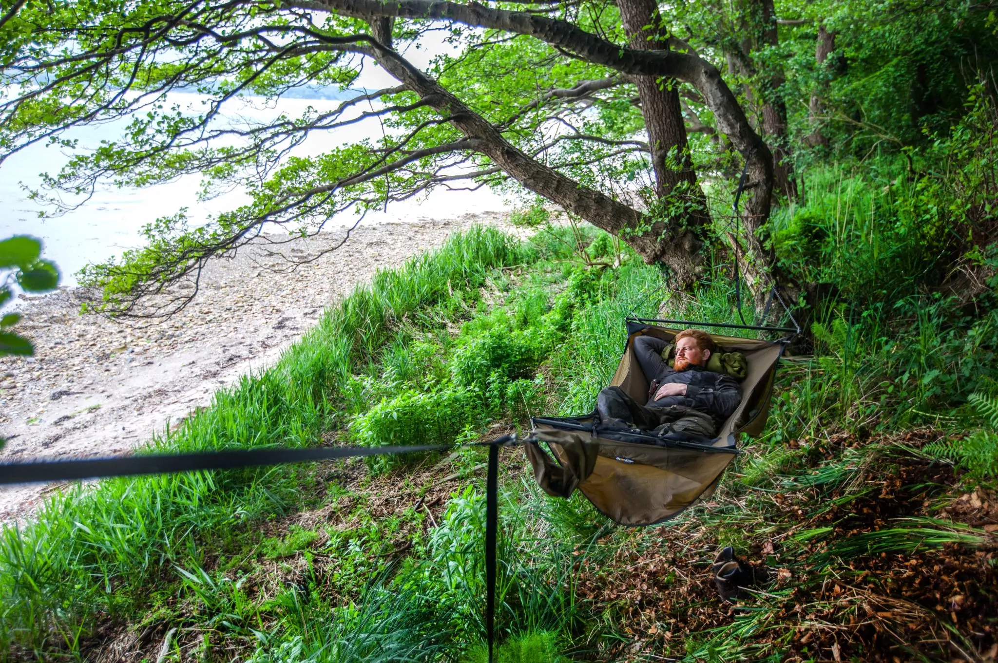 a person laying in a brown ridgerunner hammock