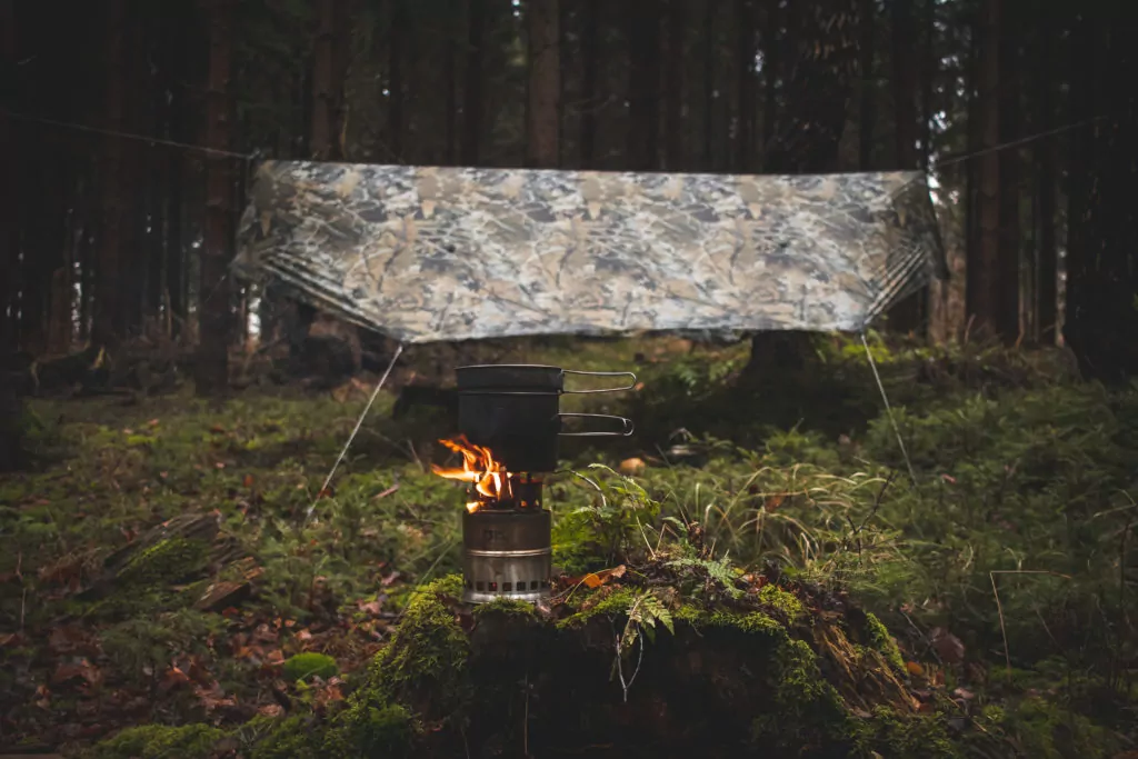 close up photo of a camp stove in front of a Bushwack Camouflage tarp