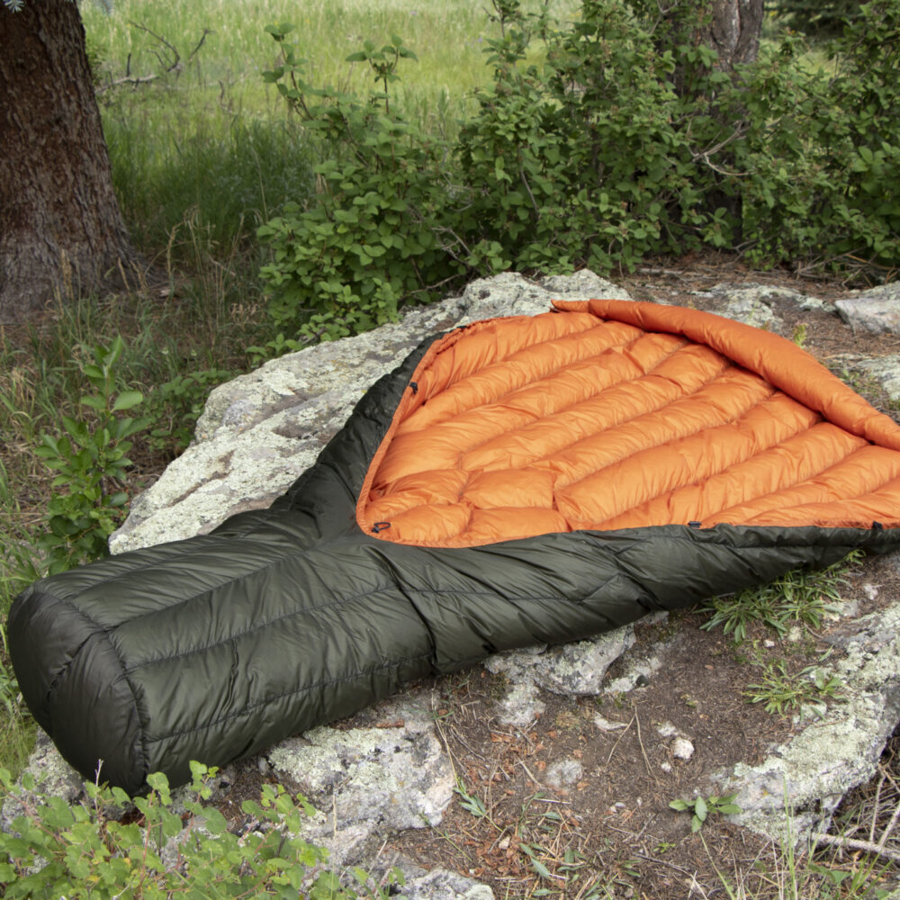 dark foliage green and autumn orange diamondback top quilt displayed outside on a rock