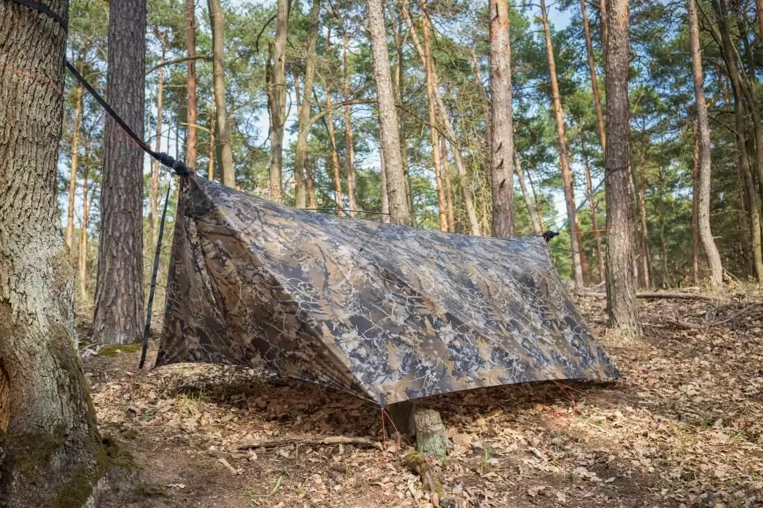 Bushwack camo tarp set up in a wooded area